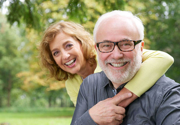 man sitting and holding the woman's hand that's wrapped around his shoulder